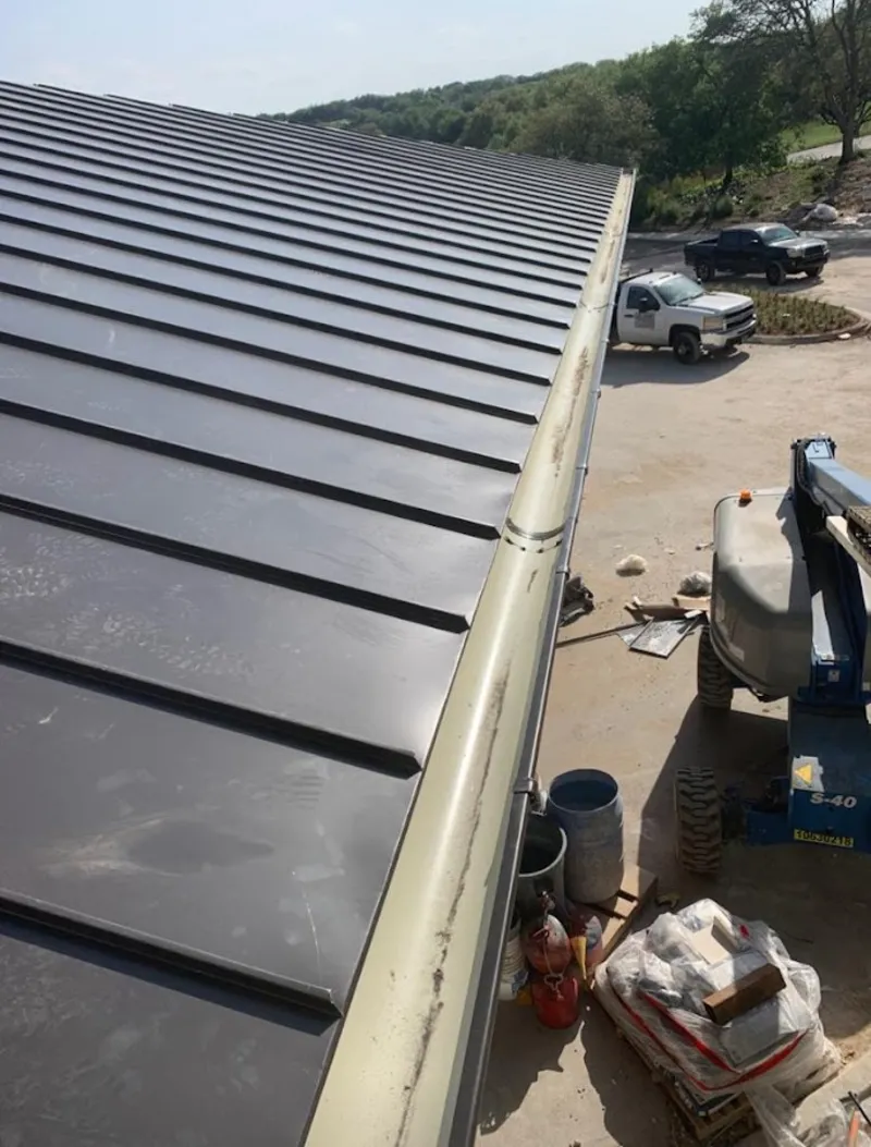 Standing seam panel and gutter detail on a metal roofing jobsite in Walden